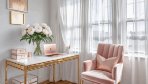 Styled home office with white walls, gold desk accessories, fresh white peonies, natural light through sheer curtains, feminine touches like a blush velvet chair and rose gold laptop, organized with pretty storage boxes